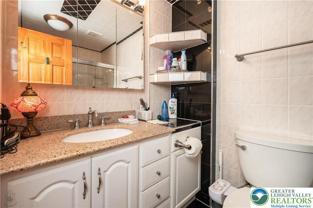 990 Hill Dr, Lower Macungie Twp, PA 18103 - full bath featuring tile walls, toilet, vanity, backsplash, and tiled shower