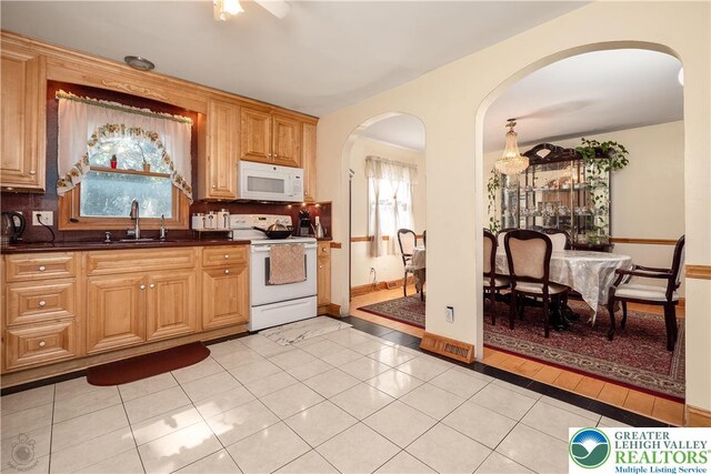 990 Hill Dr, Lower Macungie Twp, PA 18103 - kitchen featuring white appliances, arched walkways, a sink, dark countertops, and decorative backsplash