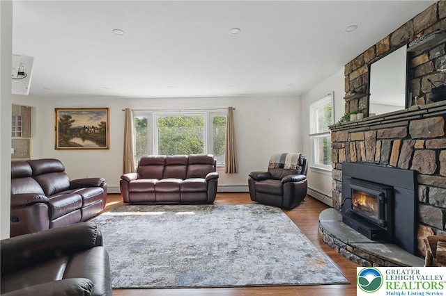 116 Peechatka, Pocono Twp, PA 18332 - living room featuring a baseboard radiator, wood finished floors, a stone fireplace, and baseboard heating