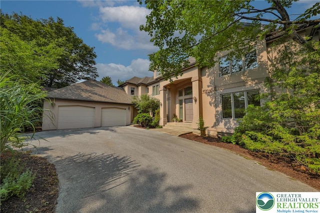 1731 Penns Xing, South Whitehall Twp, PA 18104 - view of front of home featuring stucco siding, asphalt driveway, and a garage