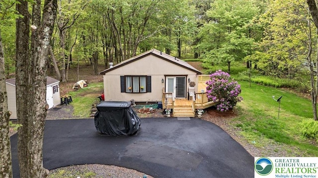 138 Drakes Dr, Penn Forest Twp, PA 18229 - view of front of property featuring a forest view, a deck, and a front yard