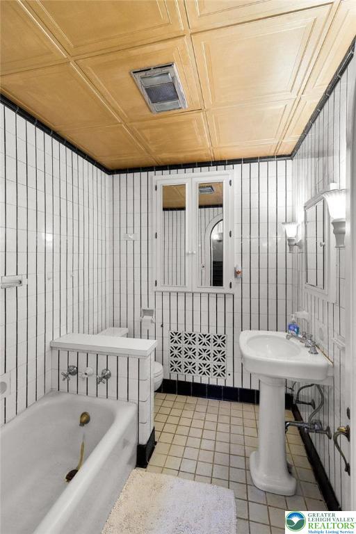923 N Webster, Lackawanna, PA 18510 - bathroom with an ornate ceiling, tile patterned floors, a bathtub, and toilet
