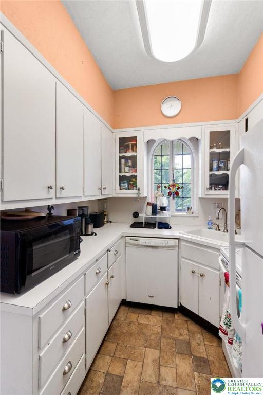 923 N Webster, Lackawanna, PA 18510 - kitchen with white appliances, stone tile floors, a sink, and white cabinetry