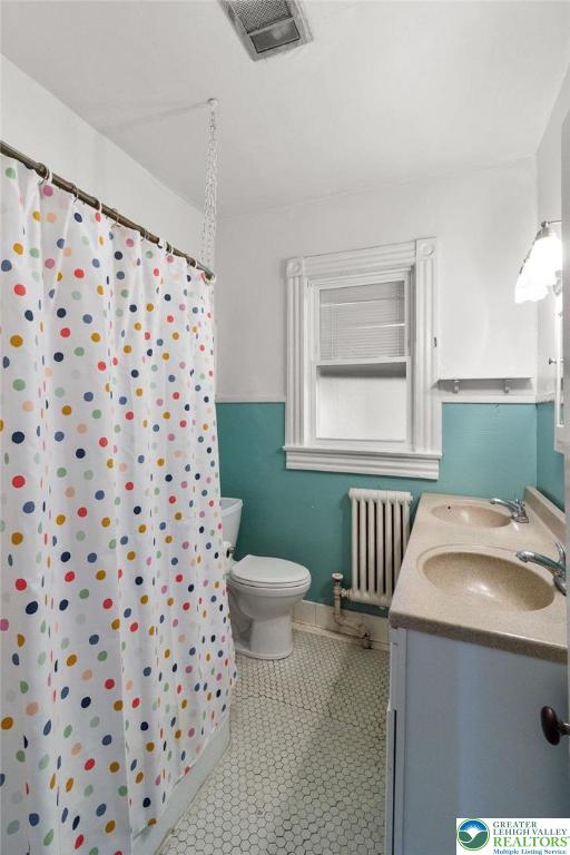 923 N Webster, Lackawanna, PA 18510 - bathroom featuring radiator, toilet, double vanity, and a shower with shower curtain