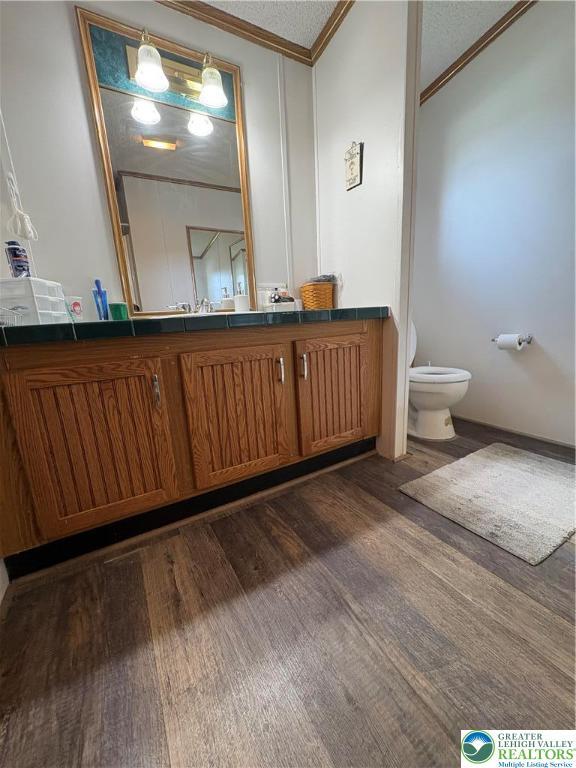 10188 Cork Ln, Upper Macungie Twp, PA 18031 - bathroom with crown molding, toilet, wood finished floors, and vanity