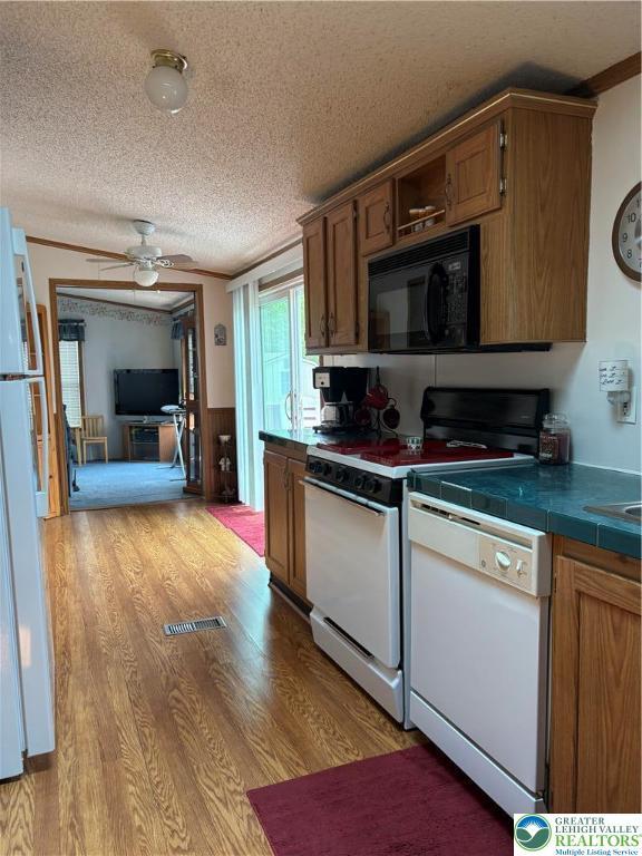 10188 Cork Ln, Upper Macungie Twp, PA 18031 - kitchen featuring white appliances, ceiling fan, a wainscoted wall, a textured ceiling, and light wood-style floors