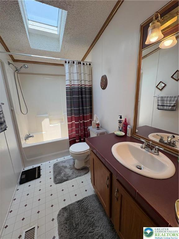 10188 Cork Ln, Upper Macungie Twp, PA 18031 - bathroom with a skylight, vanity, shower / bathtub combination with curtain, a textured ceiling, and toilet