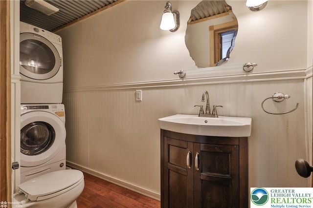 3679 Friedens Rd, Washington Twp, PA 18080 - bathroom featuring stacked washer / dryer, wood finished floors, wainscoting, vanity, and toilet