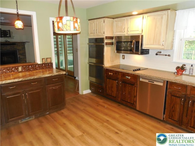 3554 Magnolia Dr, Bethlehem Twp, PA 18045 - kitchen featuring appliances with stainless steel finishes, light wood-style flooring, light stone counters, and pendant lighting