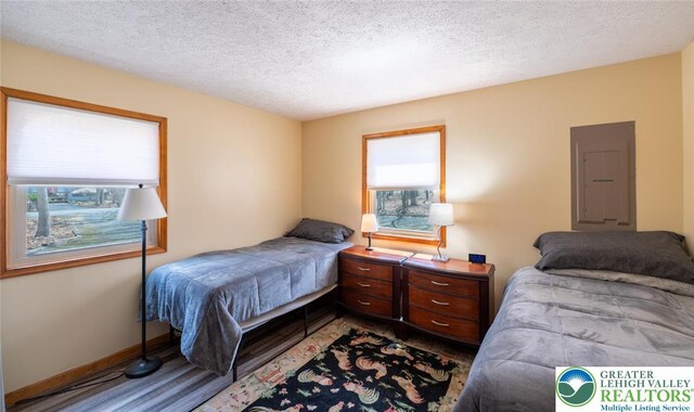 354 Kilmer Trl, Penn Forest Twp, PA 18210 - bedroom featuring electric panel, a textured ceiling, wood finished floors, and baseboards