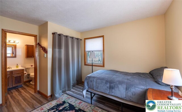 354 Kilmer Trl, Penn Forest Twp, PA 18210 - bedroom with wood finished floors, ensuite bath, a textured ceiling, and baseboards