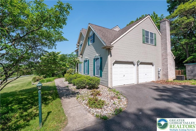 730 Buttermilk Rd, Williams Twp, PA 18055 - view of side of property featuring driveway, a garage, a chimney, roof with shingles, and a lawn