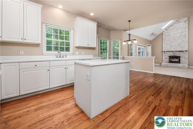 730 Buttermilk Rd, Williams Twp, PA 18055 - kitchen with light wood-style floors, white cabinetry, lofted ceiling, a kitchen island, and light countertops