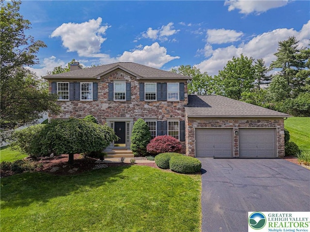 697 Ryan Dr, South Whitehall Twp, PA 18103 - colonial home with stone siding, a chimney, driveway, and a front yard