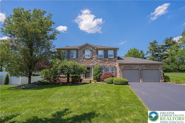 697 Ryan Dr, South Whitehall Twp, PA 18103 - colonial house featuring driveway, stone siding, and a garage