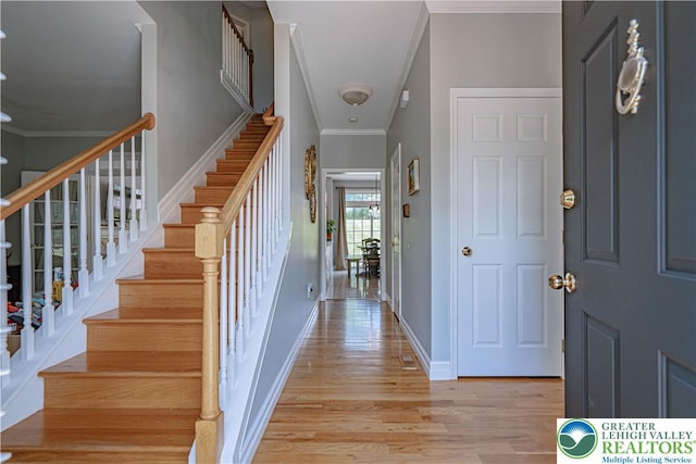 697 Ryan Dr, South Whitehall Twp, PA 18103 - foyer featuring crown molding, light wood-style floors, stairs, and baseboards