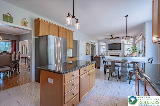 697 Ryan Dr, South Whitehall Twp, PA 18103 - kitchen featuring open floor plan, light tile patterned flooring, a fireplace, ceiling fan, and dark stone counters