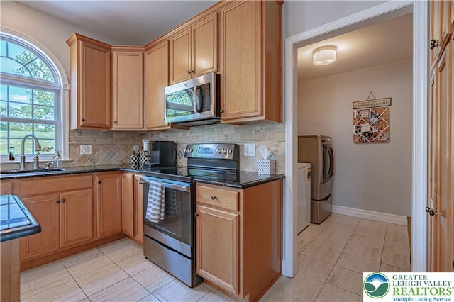 697 Ryan Dr, South Whitehall Twp, PA 18103 - kitchen featuring stainless steel appliances, a sink, washer and clothes dryer, light tile patterned flooring, and tasteful backsplash