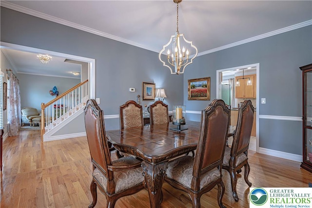 697 Ryan Dr, South Whitehall Twp, PA 18103 - dining area with a chandelier, light wood-style floors, ornamental molding, baseboards, and stairs