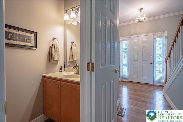 697 Ryan Dr, South Whitehall Twp, PA 18103 - bathroom with vanity, a chandelier, wood finished floors, crown molding, and baseboards