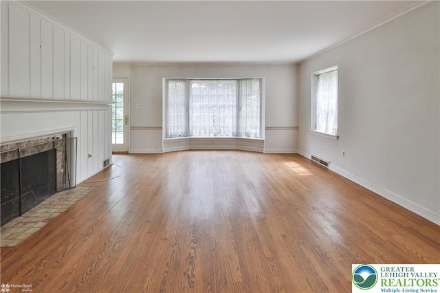 145 N Main St, Allentown City, PA 18104 - unfurnished living room featuring wood finished floors, a tile fireplace, baseboards, and crown molding