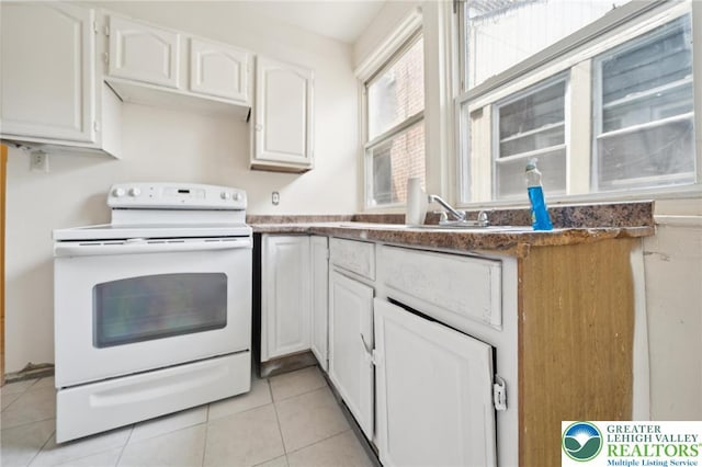 605 N 9th St, Allentown City, PA 18102 - kitchen with white range with electric cooktop, white cabinetry, a sink, and light tile patterned floors