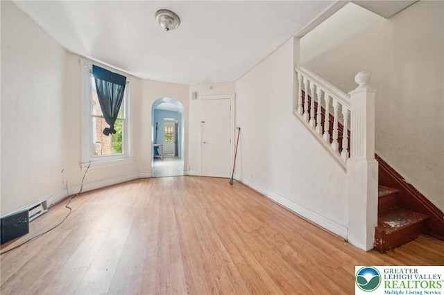 605 N 9th St, Allentown City, PA 18102 - unfurnished living room with arched walkways, wood finished floors, stairs, and baseboards