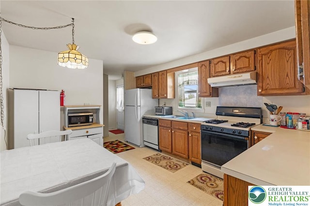 4 Davis St, Luzerne, PA 18706 - kitchen with under cabinet range hood, appliances with stainless steel finishes, light flooring, light countertops, and brown cabinetry