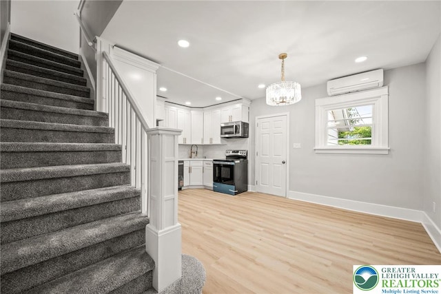 541 Elm St, Emmaus Borough, PA 18049 - staircase with a wall unit AC, wood finished floors, a chandelier, baseboards, and recessed lighting