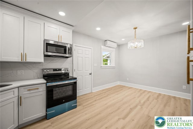 541 Elm St, Emmaus Borough, PA 18049 - kitchen featuring stainless steel appliances, a wall unit AC, baseboards, backsplash, and light wood finished floors