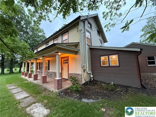 7201 Suter Rd, Coopersburg Borough, PA 18036 - view of front of home featuring stucco siding, stone siding, a front lawn, and a porch