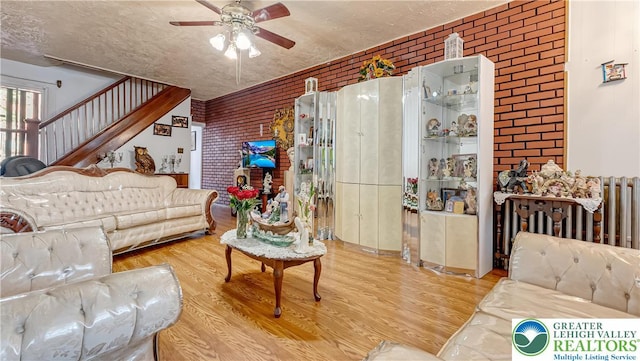 718 Jordan St, Allentown City, PA 18102 - living room with brick wall, ceiling fan, wood finished floors, and stairway