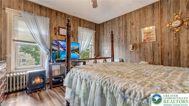 718 Jordan St, Allentown City, PA 18102 - bedroom featuring wood walls, a wood stove, radiator, and wood finished floors
