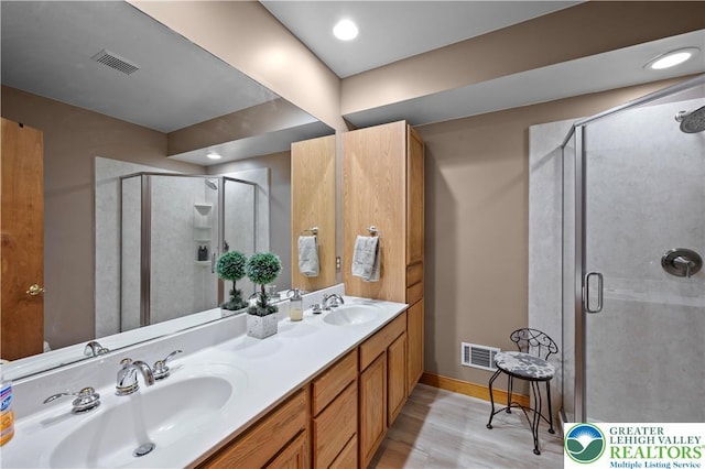 3353 Spring Valley Rd, Washington Twp, PA 18080 - bathroom featuring wood finished floors, double vanity, a stall shower, and baseboards