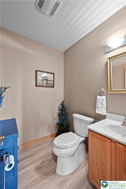 3353 Spring Valley Rd, Washington Twp, PA 18080 - half bath featuring vanity, toilet, wood finished floors, and baseboards