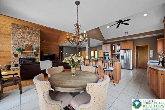 3353 Spring Valley Rd, Washington Twp, PA 18080 - dining room with wood walls, light tile patterned flooring, a ceiling fan, high vaulted ceiling, and a fireplace