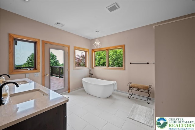 3353 Spring Valley Rd, Washington Twp, PA 18080 - bathroom featuring a freestanding bath, double vanity, baseboards, and a chandelier