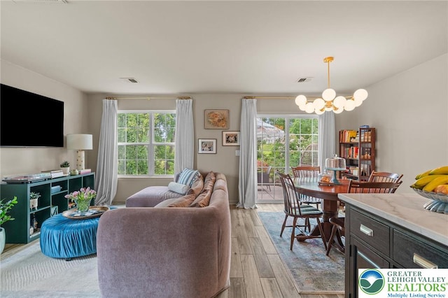 707 Blue Heron Dr, Allentown City, PA 18103 - living room with a chandelier, plenty of natural light, and light wood-style floors