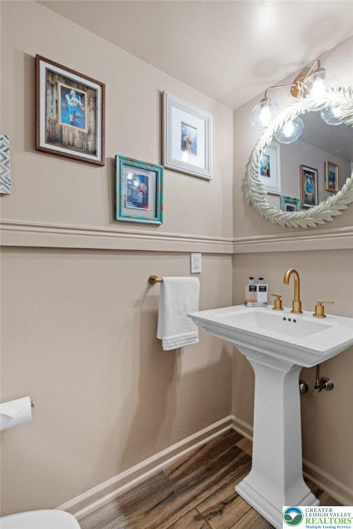 707 Blue Heron Dr, Allentown City, PA 18103 - bathroom with baseboards, wood finished floors, toilet, and a sink