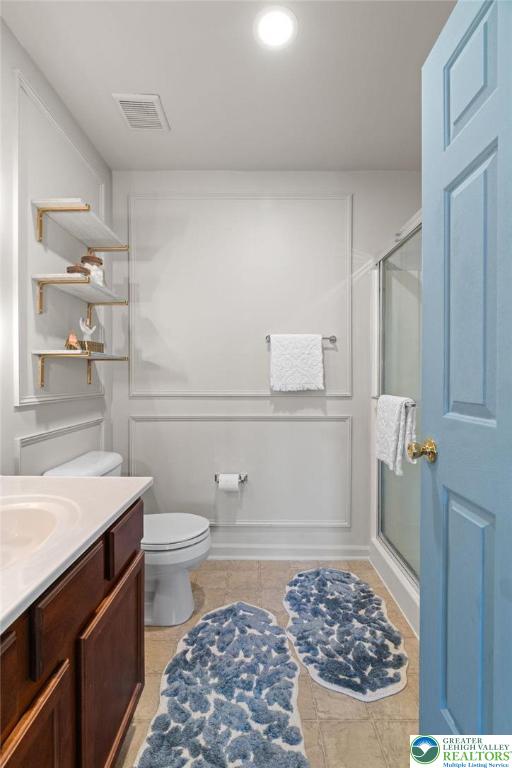 707 Blue Heron Dr, Allentown City, PA 18103 - bathroom featuring toilet, vanity, a stall shower, and tile patterned floors