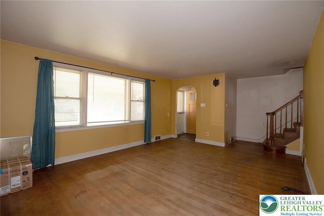 665 Furnace St, Emmaus Borough, PA 18049 - unfurnished living room featuring arched walkways, wood finished floors, and baseboards