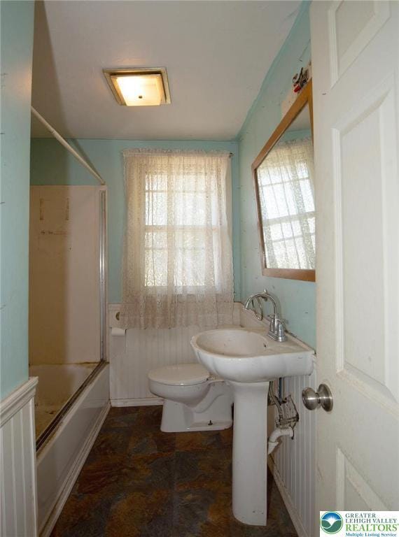 665 Furnace St, Emmaus Borough, PA 18049 - full bath with toilet, shower / bath combination with glass door, wainscoting, and stone finish floors