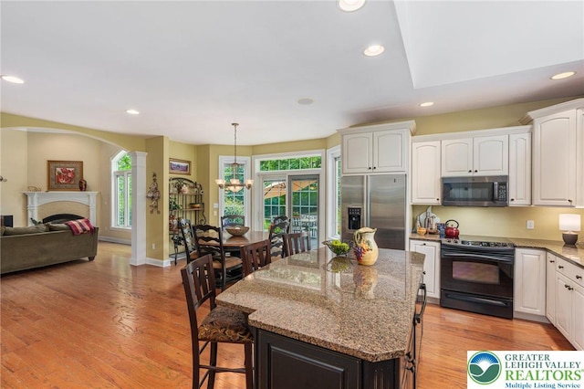 6335 Sweetbriar Ln, Upper Milford Twp, PA 18092 - kitchen with appliances with stainless steel finishes, a breakfast bar, light stone countertops, white cabinetry, and recessed lighting