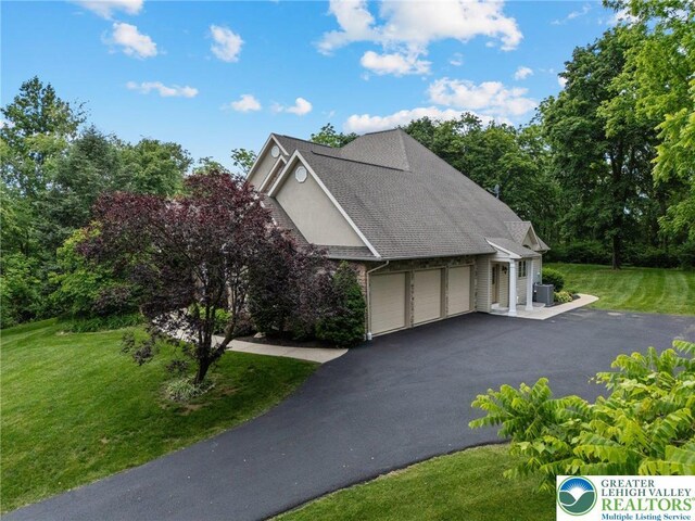 6335 Sweetbriar Ln, Upper Milford Twp, PA 18092 - view of side of home with an attached garage, asphalt driveway, and a lawn
