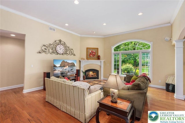 6335 Sweetbriar Ln, Upper Milford Twp, PA 18092 - living area with wood finished floors, recessed lighting, a warm lit fireplace, decorative columns, and crown molding