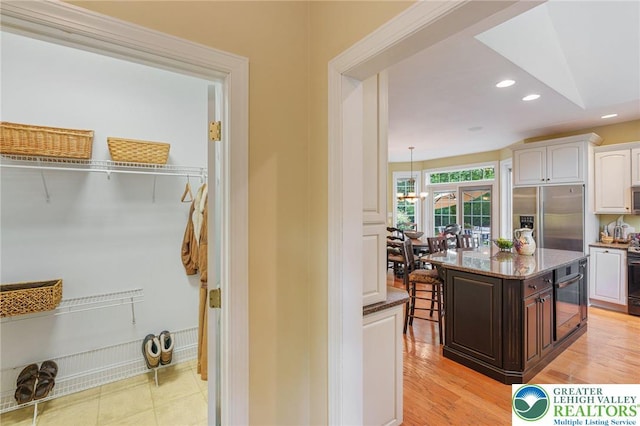 6335 Sweetbriar Ln, Upper Milford Twp, PA 18092 - kitchen featuring stainless steel fridge with ice dispenser, white cabinets, light stone countertops, recessed lighting, and dark brown cabinetry