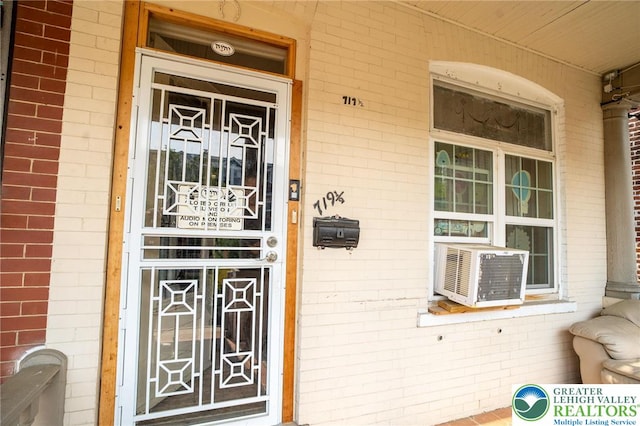 719 N 11th St, Allentown City, PA 18102 - doorway to property with a porch, brick siding, and cooling unit