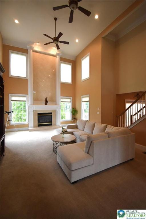 55 Forrest Stand Dr, Easton, PA 18042 - carpeted living room with a towering ceiling, ceiling fan, a glass covered fireplace, recessed lighting, and stairs