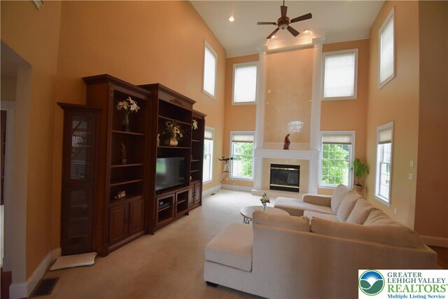 55 Forrest Stand Dr, Easton, PA 18042 - living area featuring a towering ceiling, baseboards, light colored carpet, a ceiling fan, and a premium fireplace