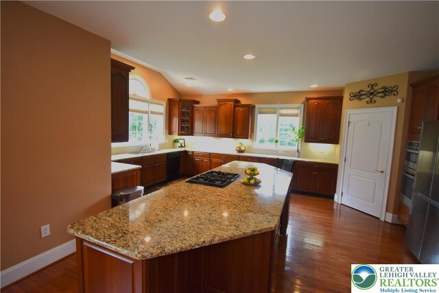 55 Forrest Stand Dr, Easton, PA 18042 - kitchen with black appliances, a sink, a center island, light stone counters, and glass insert cabinets